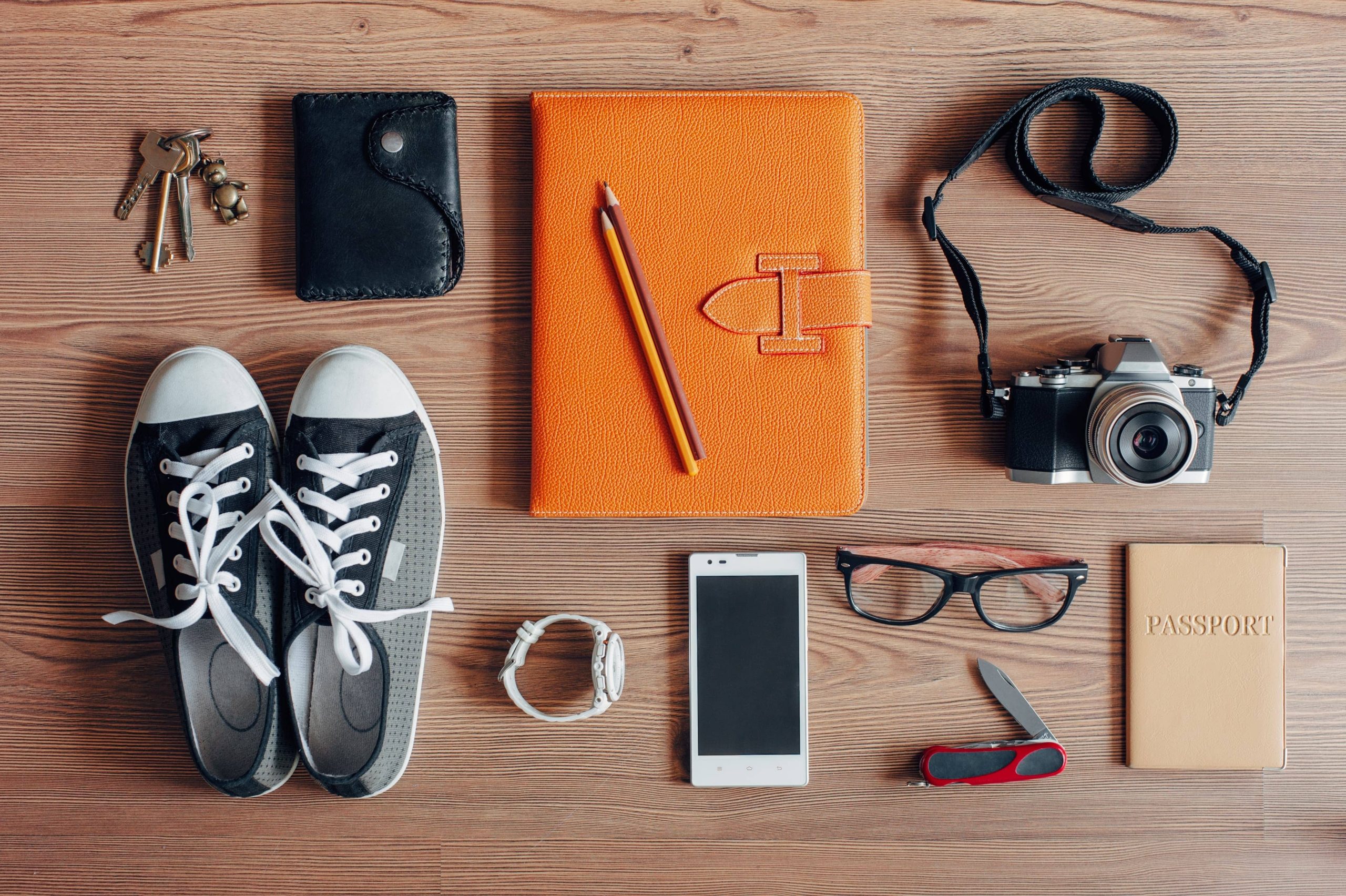 Outfit of traveler, student, teenager, young woman or guy. Overhead of essentials for modern young person. Different objects on wooden background.; Shutterstock ID 243084559