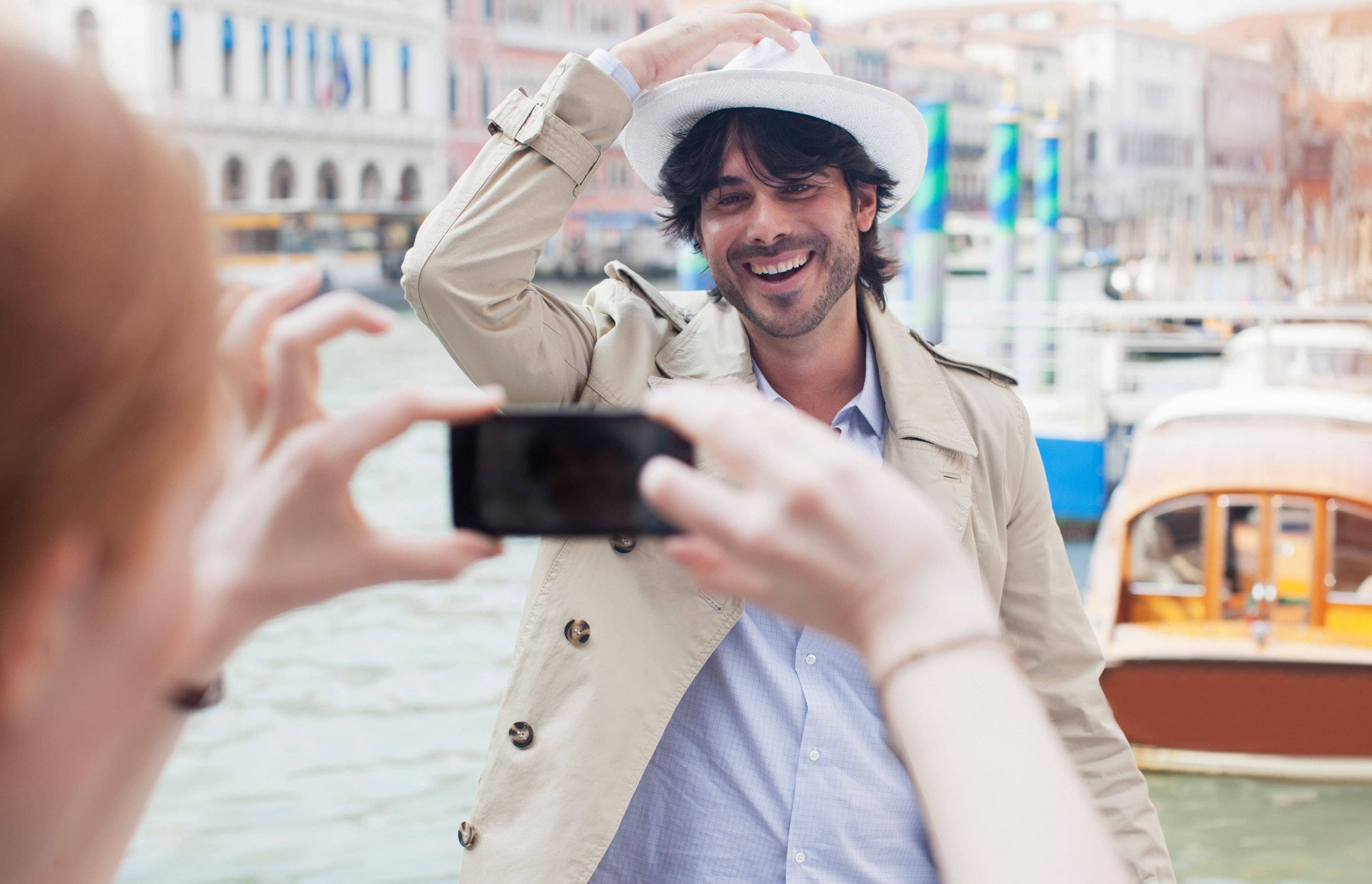 D2XJG0 Woman with camera phone photographing man at waterfront in Venice. Image shot 2012. Exact date unknown.